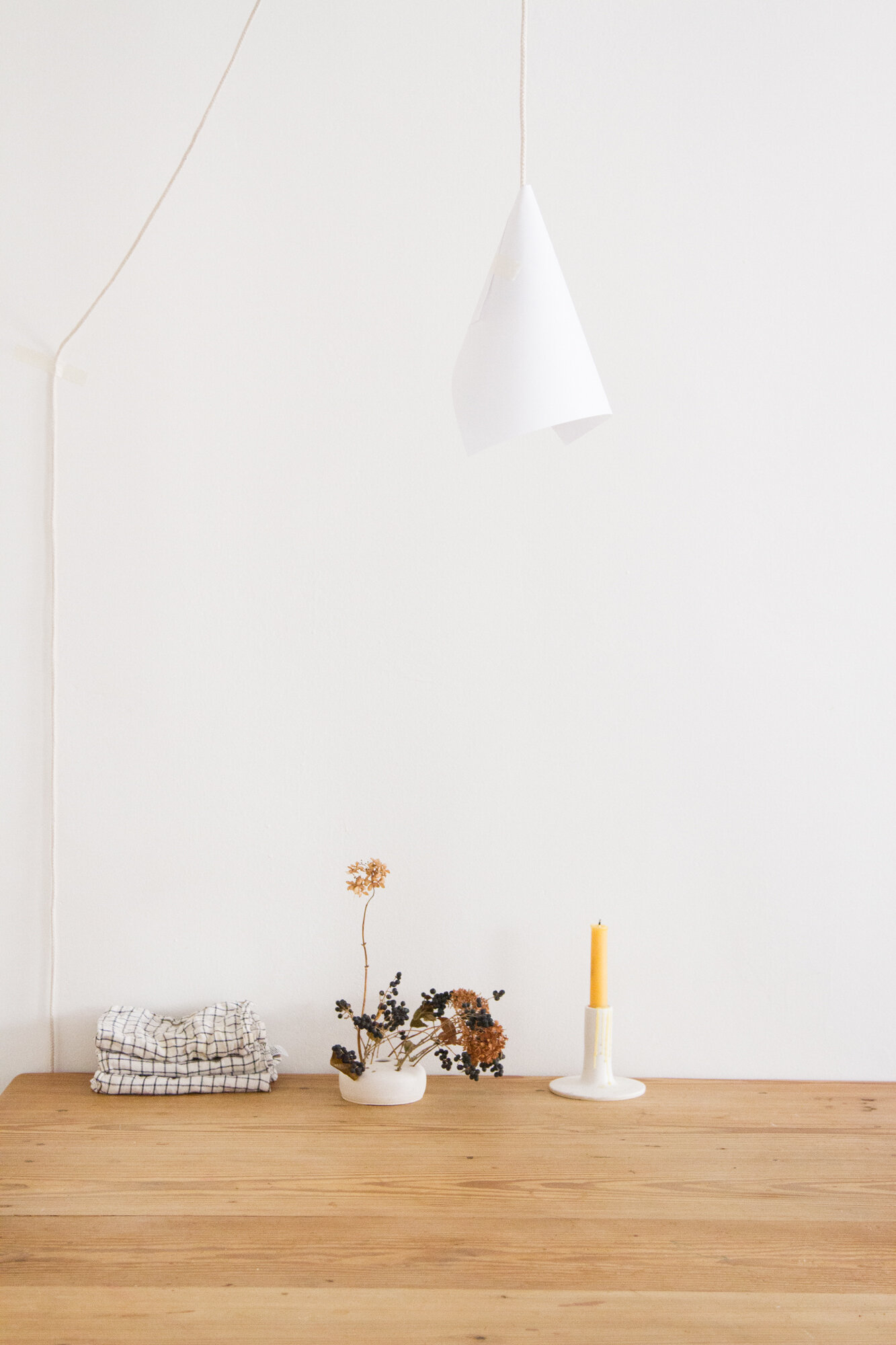 a paper and string lamp above a wooden table | reading my tea leaves